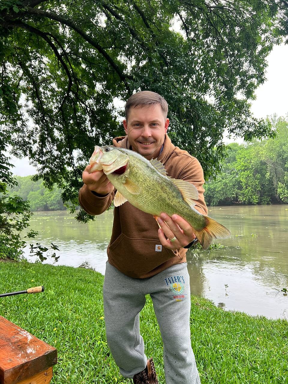 Guest holding a largemouth bass caught in the Colorado River at River Bend Bliss