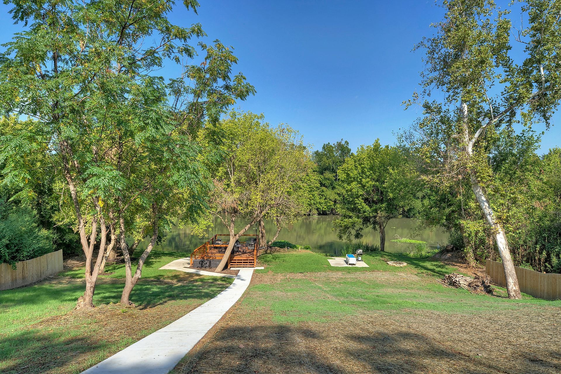 Walking path through shade trees down to the Colorado River at River Bend Bliss